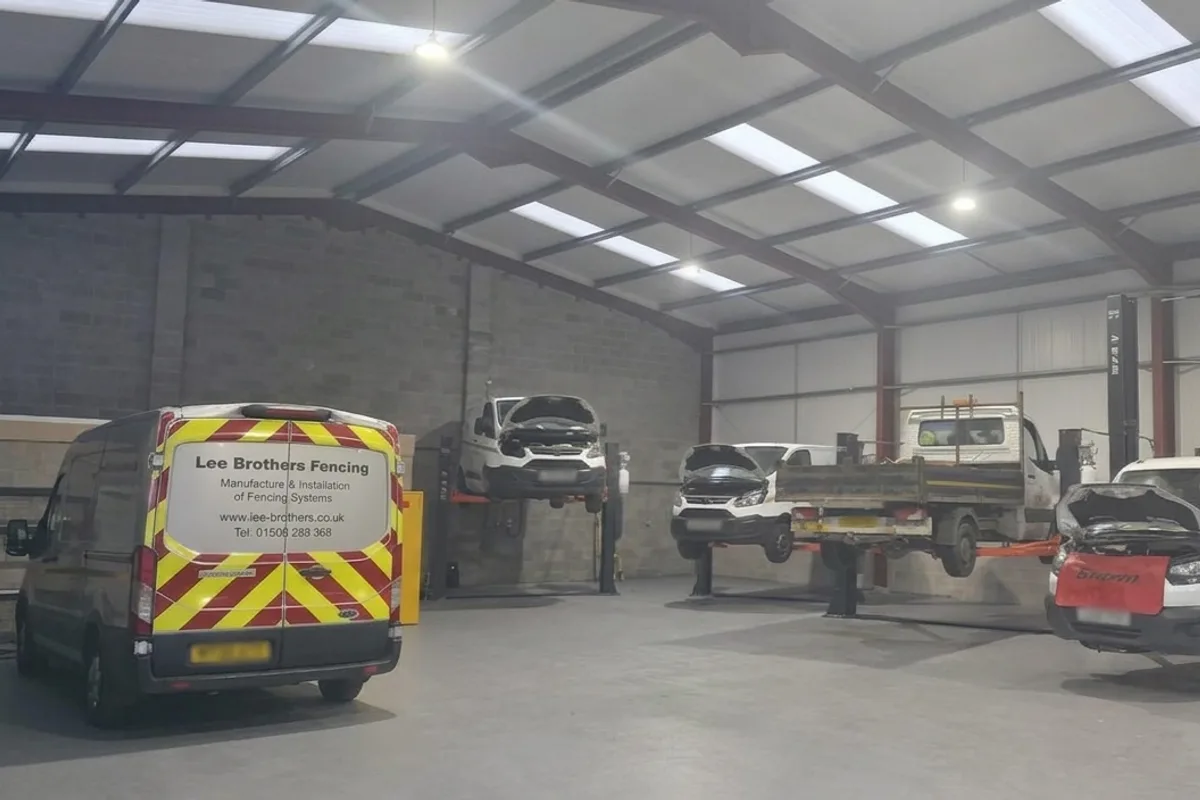 Vans and pickups raised on the two-post ramps in the Sutton Bonington workshop